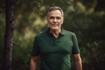 Naklejka na ściany i meble Portrait of a handsome mature man in a green polo shirt