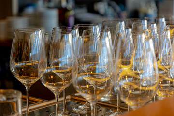 Hospitality concept, Banquet and catering party, Soft selective focus of shining wine glass, Row of glasses in the line on the counter bar with warm light, Food and beverage background.