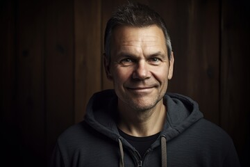 Obraz premium Portrait of a man in a black sweatshirt on a wooden background