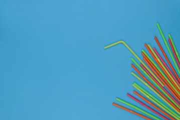 &eacute;ventail de pailles en plastique multi-couleur sur un fond bleu uni avec espace pour du texte