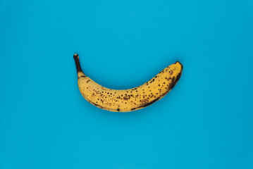 Banane mûre isolée sur un fond bleu uni