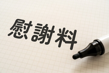 慰謝料と書かれたノートとマーカー