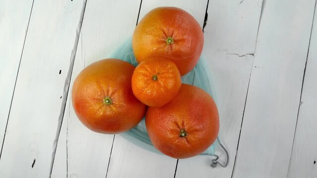 Three ripe juicy grapefruit in eco-friendly grid.