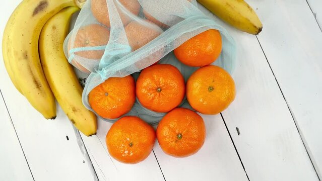 Ripe tangerines, bunch bananas in eco-friendly