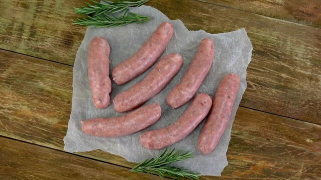 Raw pork sausage, with rosemary sprigs rotate.