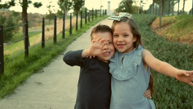 ni&ntilde;os hermanos amigos primos felices disfrutando de su amistad jugando riendo en el parque saludando al aire libre en un hermoso atardecer en un d&iacute;a soleado muy juguetones y felices