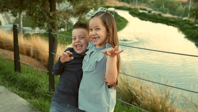 ni&ntilde;os hermanos amigos primos felices disfrutando de su amistad jugando riendo en el parque saludando al aire libre en un hermoso atardecer en un d&iacute;a soleado muy juguetones y felices