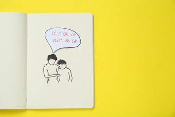 Card with phrase It`s Ok to Not Be Ok, drawing of mother and her son in notebook on yellow background, top view. Space for text