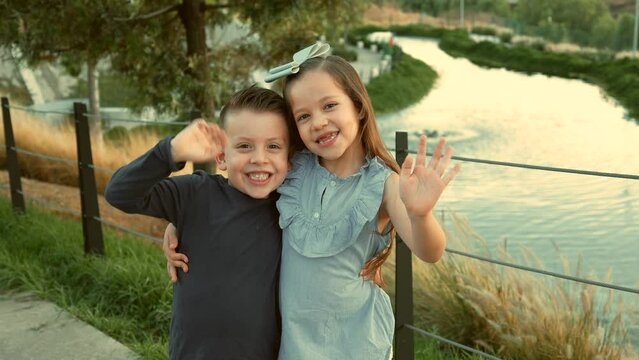 ni&ntilde;os hermanos amigos primos felices disfrutando de su amistad jugando riendo en el parque saludando al aire libre en un hermoso atardecer en un d&iacute;a soleado muy juguetones y felices