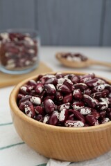 Bowl with dry kidney beans on table, closeup