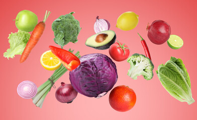 Many fresh vegetables and fruits falling on pastel red background