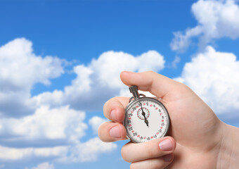 Man holding timer against beautiful sky, closeup. Space for text