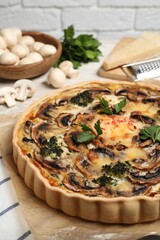 Delicious quiche with mushrooms and parsley on table, closeup