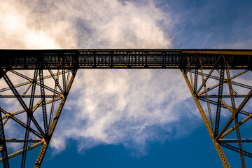Low-angle shot of metal bridge on a cloudy sky