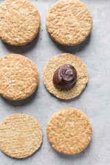 Top view of oat cookies with chocolate filling, homemade oatmeal cookies filled with chocolate, Top view of thin oat biscuits with chocolate ganache