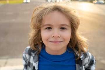 Portrait of kid boy in nature, park or outdoors. Close up face of happy child playing outdoors in summer park.