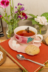 Teacup with cookies, flowers, and photo album