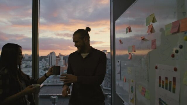 Guy silhouette thinking evening office closeup. Business couple drinking coffee