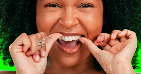 Woman, face and dental flossing on green screen for healthcare or hygiene against a studio background. Closeup of happy female cleaning teeth for healthy fresh, gum care or oral and mouth treatment
