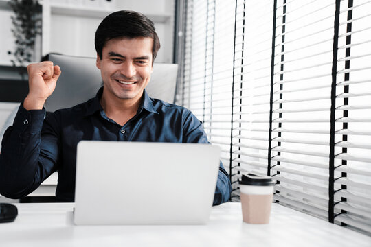 Young male employee receives a promotion, good news or finished his task and overjoyed for being a competent worker. Idea of promotion in career, reward for working hard worker.