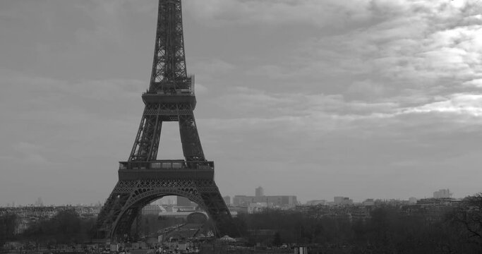 Tilt up black and white shot of Eiffel tower from famous square Trocadero, most visited attractions of Paris, France on a cloudy day.