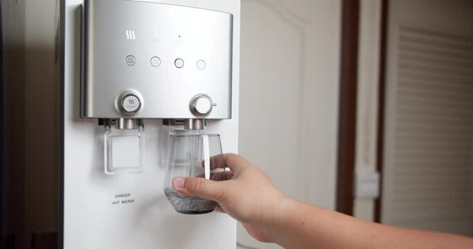Hand-pushing cup for pure water freshness for a healthy lifestyle. Modern cooler appliance. Water filtration machine.
