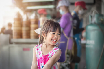 Asian little girl smiling happily at dim sum shop 