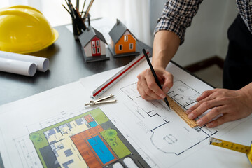 Engineer, architect, contractor starting to draw house plan structural blueprint on workbench with ruler in office at construction site to design housing plan.