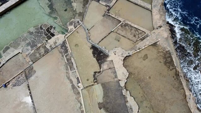 Drone view of Salt Pans in Malta island. Salt fiels surrounded by the Mediterranean sea.