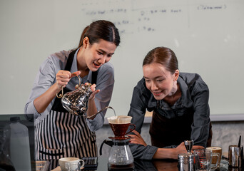 Young adult baristas follow recipes to create artisan and specialty beverages. Making drip coffee with a unique way. Small business owners practice the sense of taste and scent at slow bar coffee.
