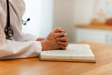Coronavirus disease Covid-19. Female doctor or nurse prays with hands together in a gesture of hope...