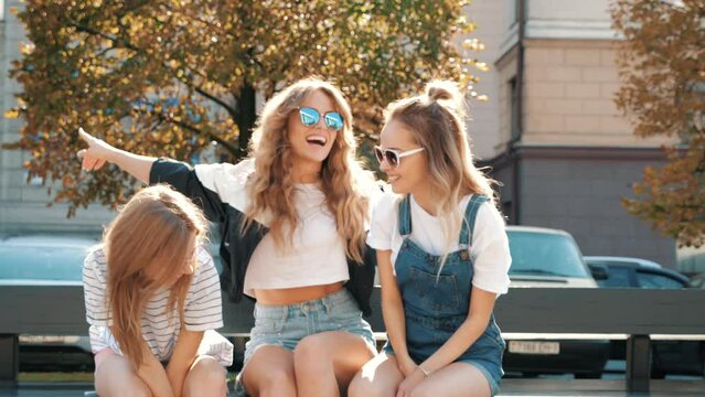 Portrait of three young beautiful smiling hipster girls in trendy summer clothes. Sexy carefree women posing in the street. Positive models having fun