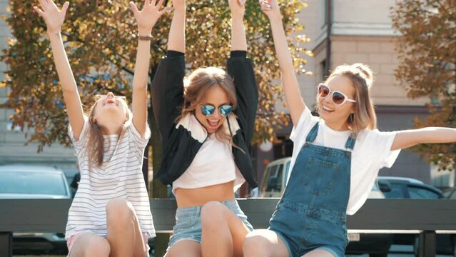 Portrait of three young beautiful smiling hipster girls in trendy summer clothes. Sexy carefree women posing in the street. Positive models having fun
