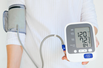 Man checks blood pressure monitor and heart rate monitor with digital pressure gauge. Health care and Medical concept.