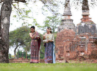 Young Asia woman with Traditional Thai dress splash water celebrate activity on Songkran festival or Thailand New year