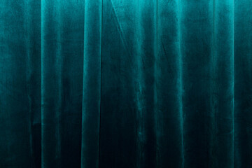 Thick turquoise velvet curtain with beautiful tails. Decor and design in the interior. Background. Space for text.