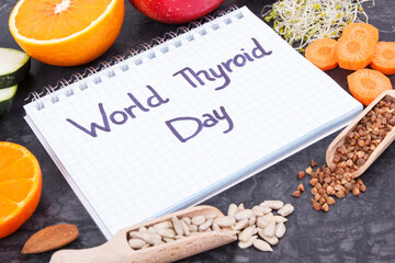 Notepad with inscription World Thyroid Day and best food containing vitamins for healthy thyroid