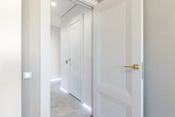 Classic style white door. Opened white door to the bathroom. Classic white door with golden handle. Close-up
