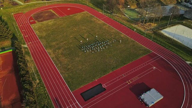 Aerial 4K drone footage of outdoor sports complex and the group of people involved in physical activity. The footage was filmed during the sunset in the small city of Ormož in Slovenia.