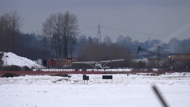 Small Cessna Airplane Taking Off From Snow Covered Local Airfield.