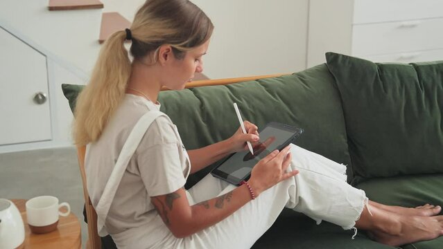 Freelance woman draws red head girl. Designer use digital pad tablet for work close up. Female illustrator paints art pic. Artist develop job skill. Painter sit office studio. Hand hold pen home room.