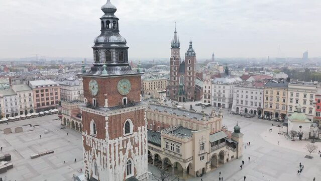 Krakow aerial view of Main Market Square during cloudy day. Drone footage of Polish monuments - Mariacki (St Mary's) Church, Sukiennice (Cloth Hall) and City Hall tower