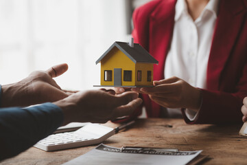 Real estate agents explain models of housing estates in projects to elaborate to clients,...
