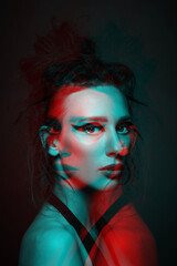 Studio portrait of beautiful woman with eye shadows and dreadlocks in red and blue color split effect style. 3D effect and futuristic looking style