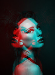 Studio portrait of beautiful woman with eye shadows and dreadlocks in red and blue color split effect style. 3D effect and futuristic looking style