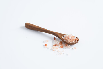 Himalayan pink salt (rock salt, halite mined) in wooden spoon isolated on white background.