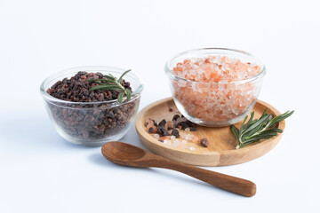 Top view of variety of different flake flower sea salt, Himalayan black salt and pink Himalayan with rosemary for cooking or spa on white background.