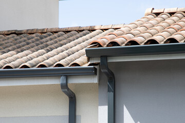 grey gutter guard system roof drip edge on modern home neighborhood