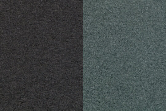 Texture of craft black and dark green paper background, half two colors, macro. Vintage dense olive cardboard.