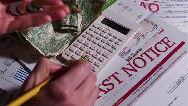 Caucasian Woman Calculating how to pay her Past Due Bills with Loose Change. Shot with ARRI Alexa in ARRIRAW at 23.98 fps and exported QuickTime Apple Pro Res 422 HQ.